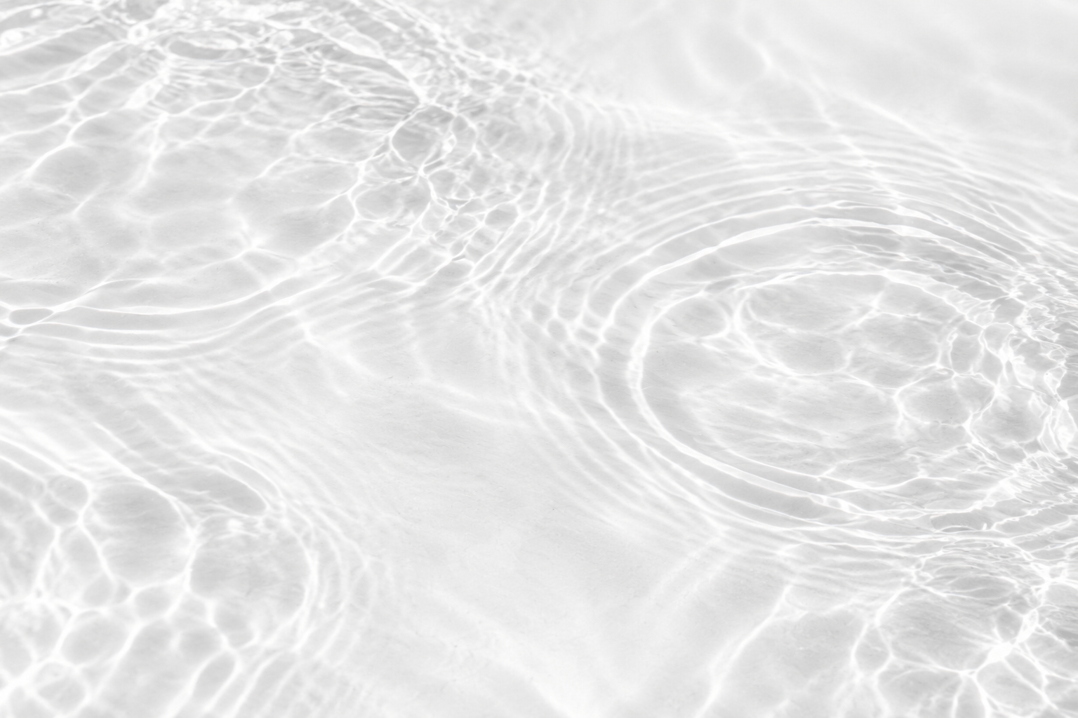 Water ripples on a white background with subtle film grain.